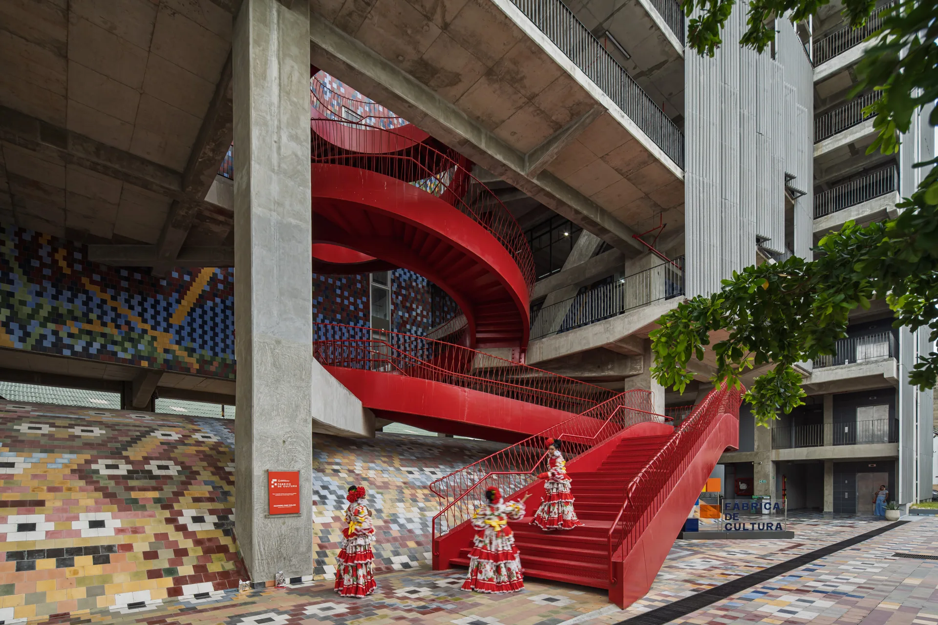 Pabellones de danza y teatro interiores con estructura de concreto visto.